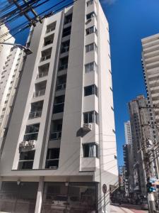 um edifício branco alto numa rua da cidade em Lindo apto 2 quartos quadra mar em Balneário Camboriú