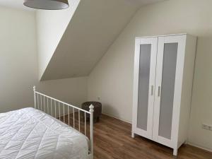 a bedroom with a bed and a white cabinet at Haus und Garten nur für Dich in Duderstadt