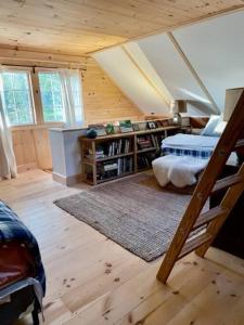 a bedroom with a loft with a bed and a book shelf at Sadawga Springs Retreat in Whitingham