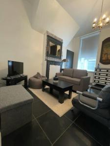 ein Wohnzimmer mit einem Sofa und einem Tisch in der Unterkunft Appartement en rez-de-chaussée in Hesdin
