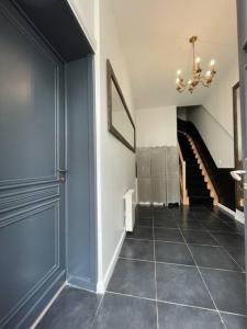 einen Flur mit blauer Tür und einer Treppe in der Unterkunft Appartement en rez-de-chaussée in Hesdin