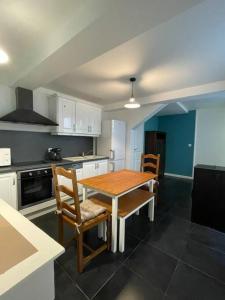eine Küche mit einem Holztisch und Stühlen in der Unterkunft Appartement en rez-de-chaussée in Hesdin