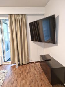 ein Wohnzimmer mit einem Flachbild-TV an der Wand in der Unterkunft Viihtyisä saunallinen kaksio lentokentän lähellä in Vantaa