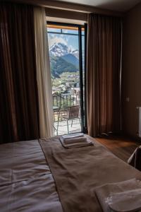 um quarto com uma cama e vista para uma montanha em ALOFT em Kazbegi