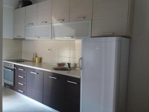 eine Küche mit einem weißen Kühlschrank und einer Spüle in der Unterkunft Lucia Apartment in Budva