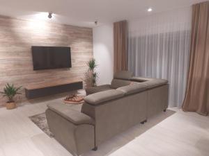 a living room with a couch and a flat screen tv at Villa Bajlo in Ždrelac