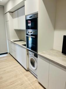 a kitchen with a stove and a washer and dryer at PISOS NUEVOS MONCLOA ARGUELLES in Madrid