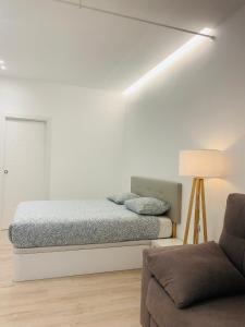 a white bedroom with a bed and a couch at PISOS NUEVOS MONCLOA ARGUELLES in Madrid