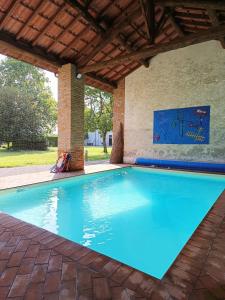 ein großer Pool unter einem Holzdach in der Unterkunft Villa Gattoni Cattaneo - Appartamento Le Magnolie in Lardara