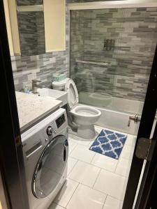 a bathroom with a toilet and a washing machine at 6-Bedroom Apartment by Central Park in New York