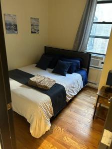 a bedroom with a large bed with blue pillows at 6-Bedroom Apartment by Central Park in New York