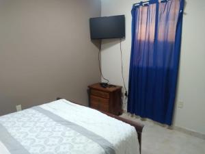 Un dormitorio con una cama y una cortina azul. en Departamentos velasco, en Tijuana 22 fotos más