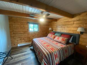 a bedroom with a bed in a log cabin at SkyWater Cabins in Hamilton