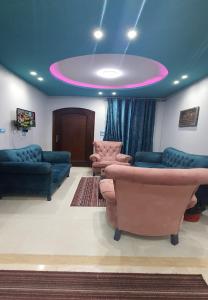 uma sala de estar com sofás e um tecto roxo em M&H Apartment em Dumyat al Jadidah