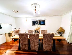 uma sala de jantar com uma mesa de madeira e cadeiras em Ocean View 3 bedroom entire house central of Caloundra em Caloundra West