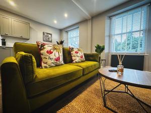 鲍内斯温德米尔1 West End Boutique Apartment的客厅里有一张绿色的沙发和一张桌子