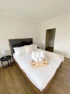 a large white bed with a wooden tray on it at Springvale Apartment in Alexandra