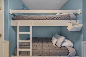 two bunk beds in a blue room with a ladder at Grand Caribbean in Perdido Key 111E by Vacation Homes Collection in Pensacola