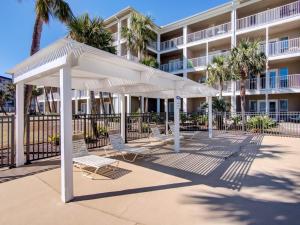 a group of white umbrellas in front of a building at Grand Caribbean in Perdido Key 111E by Vacation Homes Collection in Pensacola