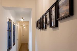 a hallway with a row of framed pictures on the wall at Apart Infante Casco Histórico de Ribadesella VUT-1322-AS in Ribadesella +16 photos