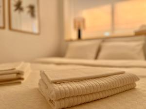 - 2 lits avec des serviettes pliées au-dessus d'une chambre dans l'établissement Sweet Sandy Beach - 1 minute walk to Mediterranean beaches, à Santa Pola
