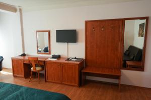 um quarto com uma secretária, um armário e um espelho em Hotel Gold Inn em Peje
