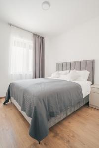 a white bedroom with a large bed and a window at BP Serviced Apartment in Budapest