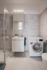 a bathroom with a washing machine and a sink at BP Serviced Apartment in Budapest