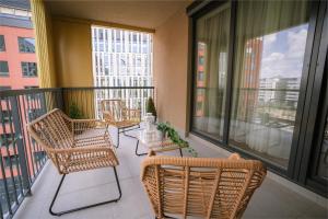 a balcony with chairs and a table and windows at BP Serviced Apartment in Budapest