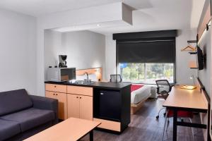 a small hotel room with a bed and a kitchen at City Express by Marriott Leon in León