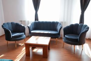 a waiting room with blue chairs and a coffee table at Hotel Gold Inn in Peje