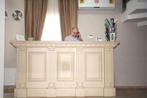 a man sitting in front of a white counter top at Old Metekhi Hotel in Tbilisi City