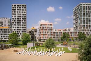 a group of white chairs in a park with buildings at BP Serviced Apartment in Budapest