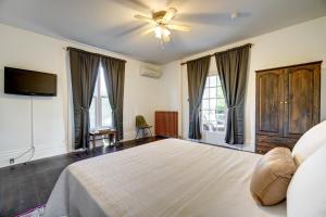 a bedroom with a bed with a ceiling fan and windows at Evangeline in Grand pré