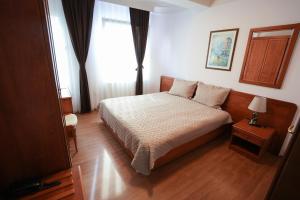 a small bedroom with a bed and a window at Hotel Gold Inn in Peje