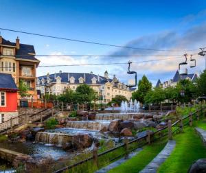 a city with a water fountain and buildings at 101 Horizon - 3 Bdrs Tremblant Ski In Out plus Spa & Sauna in Mont-Tremblant