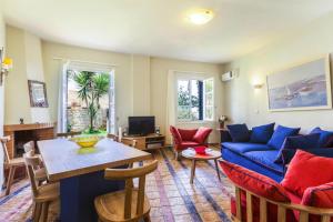 a living room with a blue couch and a table at Villa in Episkopi with private pool in episkopi-chania