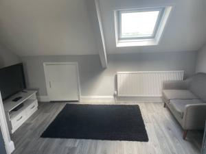 a living room with a couch and a television at Large self contained 1 bedroom flat with parking. in Plymouth