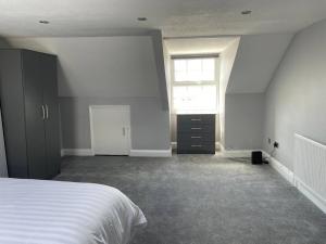an empty bedroom with a bed and a window at Large self contained 1 bedroom flat with parking. in Plymouth