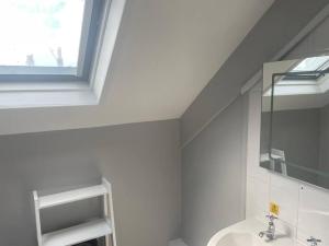 a white bathroom with a sink and a window at Large self contained 1 bedroom flat with parking. in Plymouth