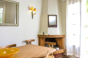 a dining room with a table and a fireplace at Villa in Episkopi with private pool in episkopi-chania