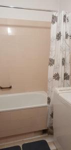 ein Bad mit einer Badewanne und einem Duschvorhang in der Unterkunft Przytulne mieszkanie m3 Gorlice in Gorlice