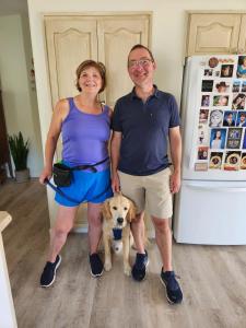 a man and a woman standing next to a dog at Sunshine and Wine Loft in Penticton