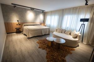 a hotel room with a bed and a white couch at Hotel Termal Los Cardones & Spa in Termas de Río Hondo