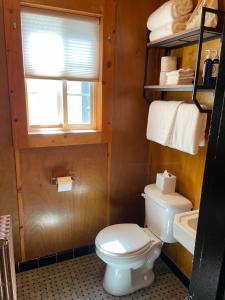 a bathroom with a toilet and a window and towels at Anchor Inn Resort in Lincoln City