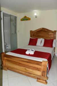 a bedroom with a large wooden bed with towels on it at Hotel Las Guacamayas Guatapé in Guatapé