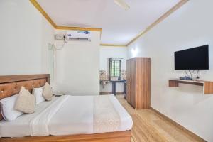 a bedroom with a large bed with a flat screen tv at Calangute Bay By The Sea in Calangute