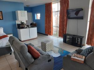 a living room with a couch and a tv at Unit 95 Oceanic - Self Catering, North Beach in Durban