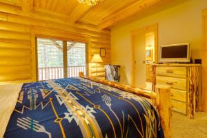 1 dormitorio con 1 cama y TV de pantalla plana en Exquisite McCall Log Cabin - Walk to Payette Lake!, en McCall