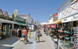 a group of people walking down a street with shops at Évasion en Bord de Mer Maison Tout Confort à La Faute-sur-Mer in La Faute-sur-Mer
